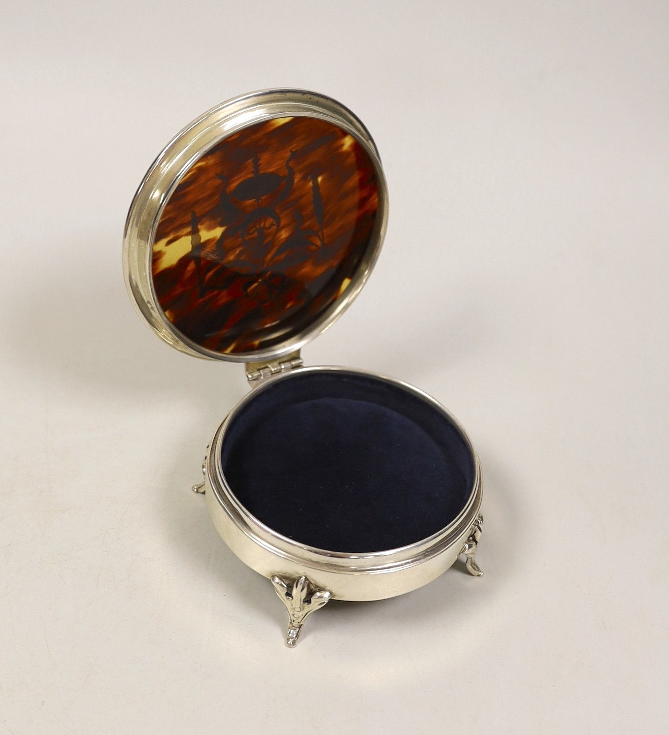 A George V silver and tortoiseshell piqué mounted circular trinket box, London, 1921, diameter 11.2cm.